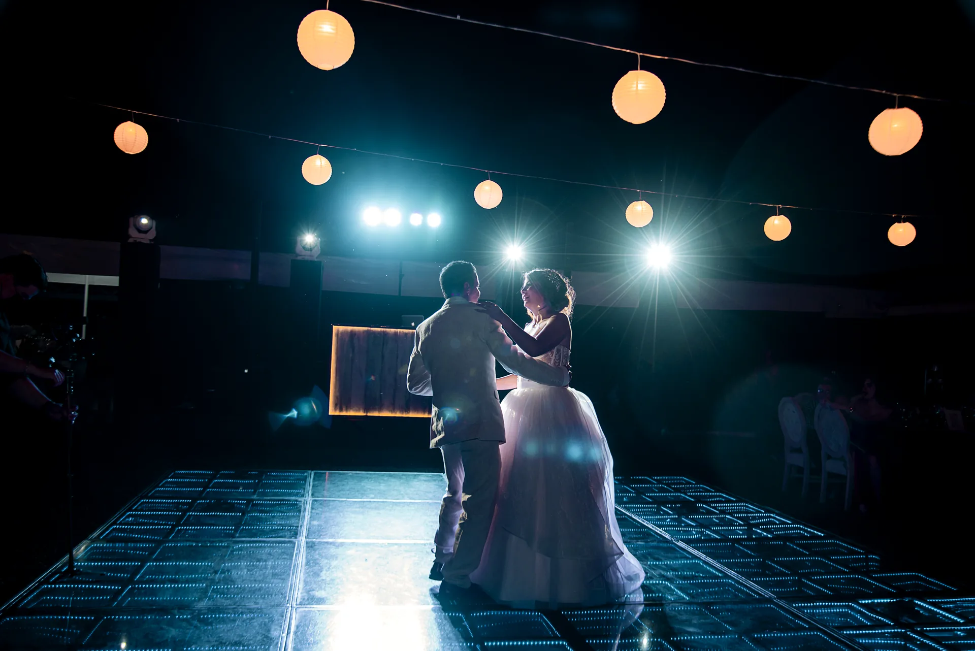 Baile de los novios bajo luces cálidas colgantes